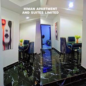 a room with a table and chairs and a door at Himan Apartment And Suites in Asipa