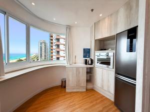 a kitchen with a large window with a view of the ocean at Wyndham Rio Barra - Oficial in Rio de Janeiro