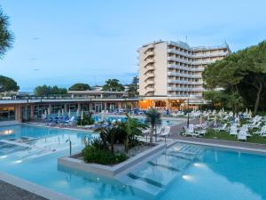 a hotel with a swimming pool and a large building at Hotel Apollo Terme in Montegrotto Terme