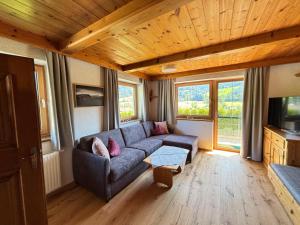 un soggiorno con un divano e alcune finestre di Sonnseit a Sankt Johann in Tirol