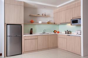 
a kitchen with a refrigerator, stove, microwave and dishwasher at Citadines Rasuna Jakarta in Jakarta

