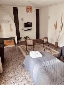 a bedroom with a bed and two chairs and a tv at Depto Güemes in Río Gallegos