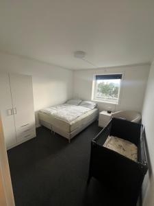 a small bedroom with a bed and a window at Basement apartment on Ulstein in Ulstein