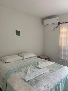 a bedroom with a bed with two pillows on it at Pousada Soleil de Genipabu in Extremóz +1 photo