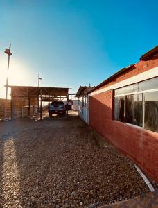 a car parked in a parking lot next to a brick building at Holgger House in Talara