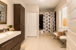 a bathroom with a sink and a door with a shower at Le Huppe - Spa Ski & River View in Petite-Rivière-Saint-François