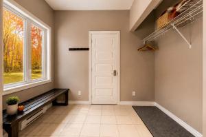 a hallway with a white door and a window at Le Huppe - Spa Ski & River View in Petite-Rivière-Saint-François