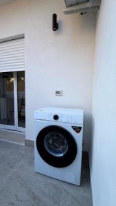 a white washing machine sitting next to a wall at San Lorenzo Palace in Reitani