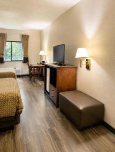 a hotel room with a bed and a flat screen tv at Days Inn by Wyndham Topeka in Topeka