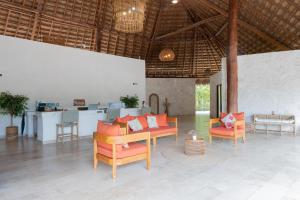 a living room with a table and chairs and a kitchen at Nalhá Hotel Boutique y Villas Bacalar in Bacalar