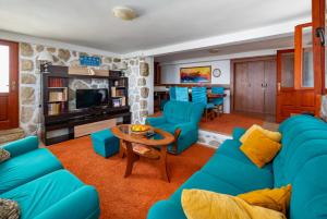 a living room with blue couches and a table at Casa Mare & Monti in Budva