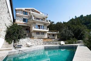 a building with a swimming pool in front of a building at Casa Mare & Monti in Budva