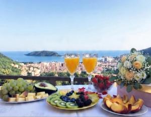 a table with plates of fruit and two glasses of juice at Casa Mare & Monti in Budva