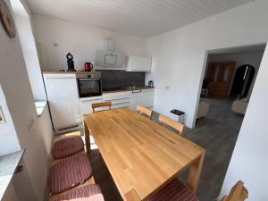 a small kitchen with a wooden table and chairs at Reden in Illingen
