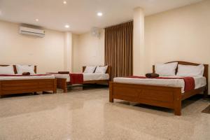 a room with two beds in a room at Aquora Pool Stays in Pondicherry