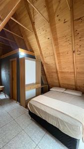 a bedroom with a bed in a wooden ceiling at Chácara Três Chalés in Foz do Iguaçu
