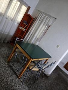 a table and a chair in a room with a window at Memento Vivere Boutique rooms in Neuquén
