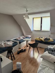 a room with three beds and two tables and chairs at Pauli Hostel in Hamburg +51 photos