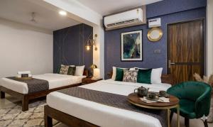 a hotel room with two beds and a table at The Velvet Anchor in Baga