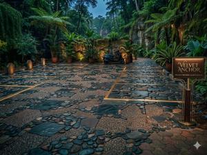 a walkway in a garden with a sign that says yard advisor at The Velvet Anchor in Baga