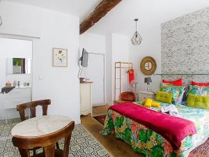 a bedroom with a bed and a table and a chair at Les Glycines Oloron in Oloron-Sainte-Marie