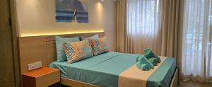 a bedroom with a bed with a stuffed animal on it at Elysee Vacances in Trou aux Biches +27 photos