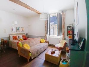 a living room with a couch and a bed at Les Glycines Oloron in Oloron-Sainte-Marie
