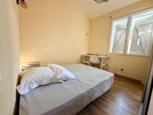 a bedroom with a bed with white sheets and a window at L'Écrin de Valensole, Charme & terrasse in Valensole