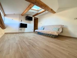 a living room with a couch and a tv at L'Écrin de Valensole, Charme & terrasse in Valensole