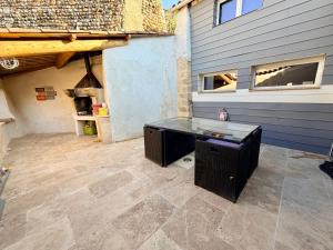 a patio with a desk in front of a building at L'Écrin de Valensole, Charme & terrasse in Valensole