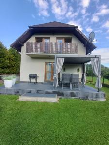 a house with a balcony and a yard at Domek nad Sołą in Cisiec +9 photos
