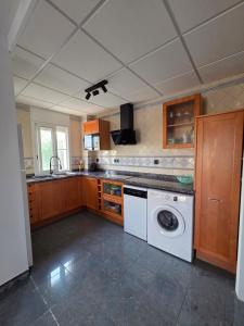 a kitchen with a washer and a washing machine at Entre Aguas in L'Eucaliptus