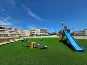 a playground with a slide on a grass field at Entre Aguas in L'Eucaliptus