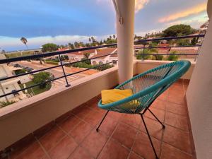 a blue chair on a balcony with a view at Entre Aguas in L'Eucaliptus