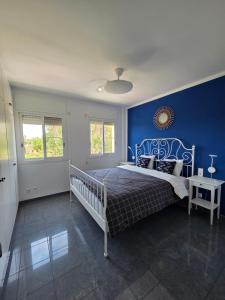 a bedroom with a bed with a blue wall at Entre Aguas in L'Eucaliptus +6 photos