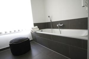 Das Bad ist mit einer Badewanne mit einer Dusche ausgestattet. in der Unterkunft Sommerloft Rerik in Rerik