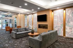 Eine Lobby mit Sofas, Fernseher und Kamin in der Unterkunft Campus Tower Suite Hotel in Edmonton