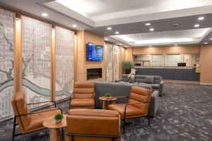 eine Lobby mit Stühlen, einem Sofa und einem Fernseher in der Unterkunft Campus Tower Suite Hotel in Edmonton