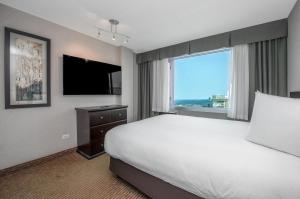 ein Hotelzimmer mit einem Bett und einem großen Fenster in der Unterkunft Campus Tower Suite Hotel in Edmonton + 45 Fotos