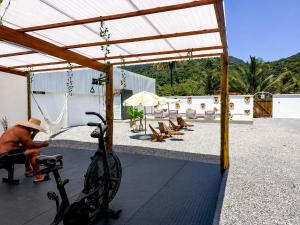 a person sitting on a bike under a pavilion at Raya Beach Studios in Maresias