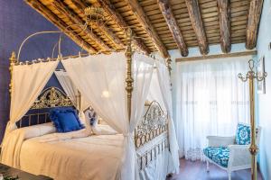 a bedroom with a canopy bed and a chair at Casa Rural El Baluarte - Grupos in Caudilla