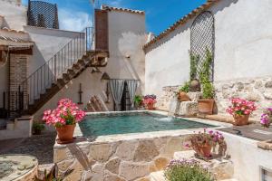 a swimming pool in the middle of a building with flowers at Casa Rural El Baluarte - Grupos in Caudilla