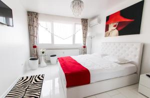 1 dormitorio con cama blanca y manta roja en Belvedere Danubius, en Galaţi