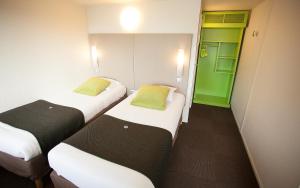 two beds in a room with green and white at Ampaline HOTEL - Perigueux Boulazac in Boulazac