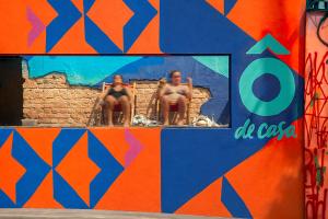 two women sitting in chairs in front of a wall at Ô de Casa Hostel Bar in São Paulo +31 photos