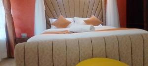 a bedroom with a large bed with a wooden headboard at Lee Njiru Resort in Nakuru +6 photos