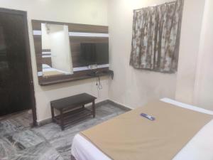 a bedroom with a bed and a mirror and a table at HoTEL LAALASA in Vijayawāda