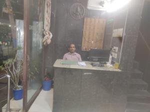 a man sitting at a desk with a computer at HoTEL LAALASA in Vijayawāda
