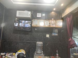 a kitchen with a wall with shelves and a air conditioner at HoTEL LAALASA in Vijayawāda