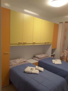 two beds in a room with yellow cabinets at Desulo - B&B Perla Del Gennargentu in Desulo